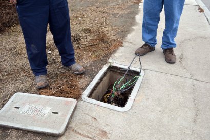 City workers inspect the site of an attempted copper wire theft Wednesday morning, Dec. 11.